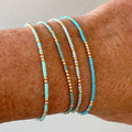 Armbånd i bått på et solbrunt håndledd.